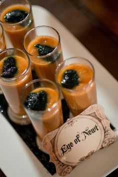 several glasses filled with orange juice on top of a white plate