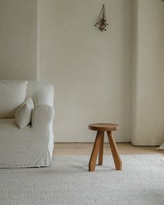 a living room with a white couch and small table in the middle of the room