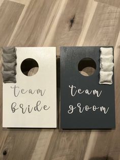 two door hangers with the words team bride and groom on them, sitting on a wooden floor