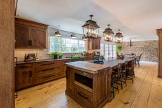 a large kitchen with wooden floors and lots of counter space, including an island in the middle