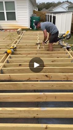 a man is working on the roof of a house with wood planks in front of him