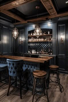 a bar with stools and bottles on the shelves