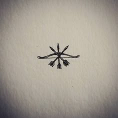 an embroidered snowflake with four arrows on it's side, in black and white