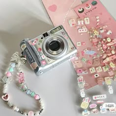 a camera sitting on top of a table next to a bunch of stickers and beads