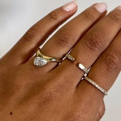 a woman's hand with two rings on it and one has a diamond in the middle