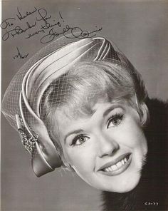 an old black and white photo of a woman with a veil on her head smiling