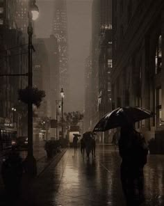 people walking in the rain with umbrellas on a city street