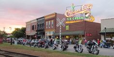 a group of motorcycles parked in front of a building on the side of a road