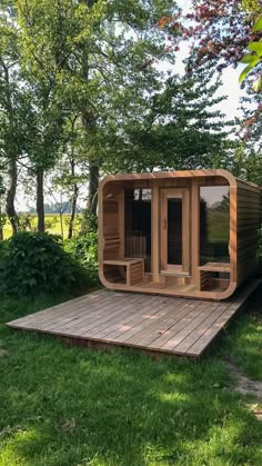 a wooden sauna in the middle of some grass