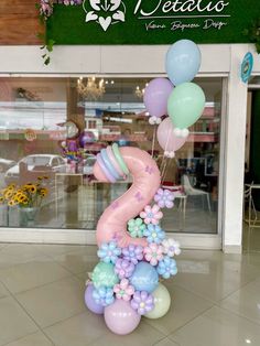 a number three balloon sculpture in the middle of a store floor with flowers and balloons