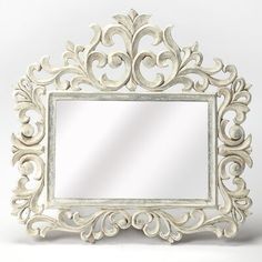 an ornate white framed mirror on a white background