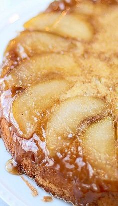 a close up of a cake on a plate with caramel sauce and sliced apples