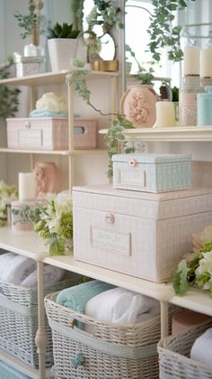 the shelves are filled with boxes and baskets full of flowers, candles, and towels