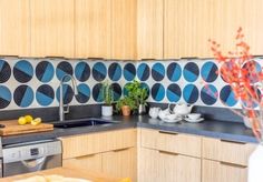 a kitchen with wooden cabinets and blue circles on the backsplash