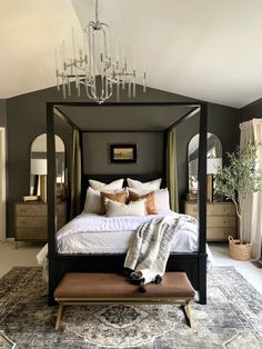 a bedroom with a canopy bed and chandelier