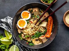 a bowl filled with noodles and vegetables next to chopsticks