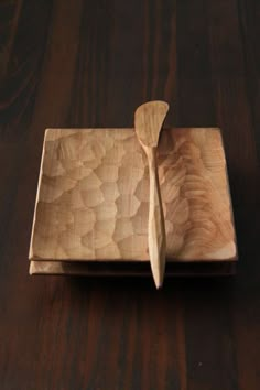 a wooden cutting board with a knife and spoon