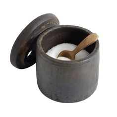 an old mortar and salt container with a wooden spoon in the top, on a white background