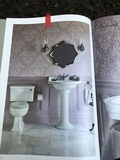 an open magazine showing a bathroom with toilet and sink in the corner, along with a mirror on the wall