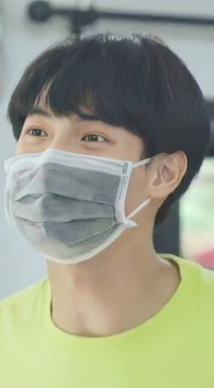 a young man wearing a face mask and looking at the camera