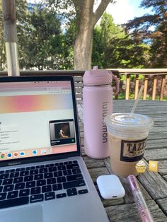 an open laptop computer sitting on top of a wooden table next to a cup of coffee