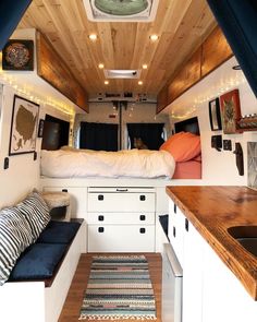 the interior of a camper with wood paneling and blue curtains on the ceiling