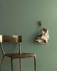 a pair of ice skates hanging on the wall next to a chair