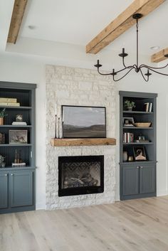 a living room filled with furniture and a fire place under a chandelier hanging from the ceiling