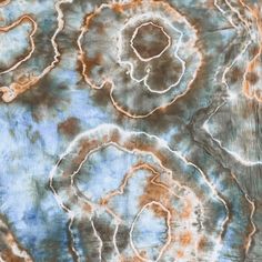 an abstract painting with brown, blue and white swirls on the surface is shown