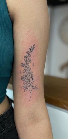 a woman's arm with a flower tattoo on the back of her left arm