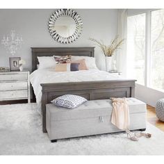 a bedroom with a bed, dresser and mirror in it's centerpieces