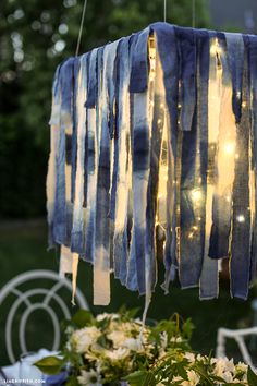 a table with flowers and lights hanging from it