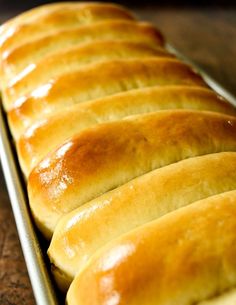 bread loafs lined up in a row on a baking sheet, ready to be baked