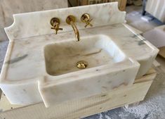 a marble sink with two golden faucets on it