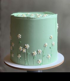 a green cake with white flowers on it