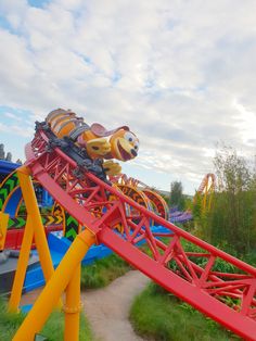 the roller coaster is red and yellow with a teddy bear on it's back