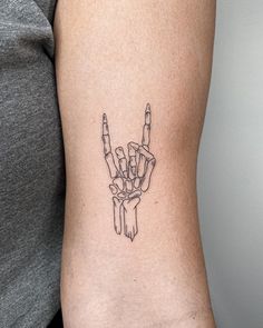 a woman with a tattoo on her arm shows the peace sign