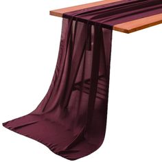 a wooden bench with purple fabric draped over it