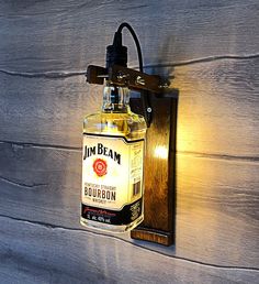 a light that is on the side of a wall next to a wooden plaque with an image of a bourbon bottle