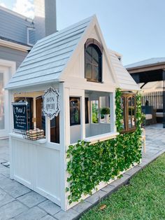 a small white house with ivy growing on it's side