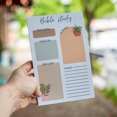 a hand holding up a planner with plants on it