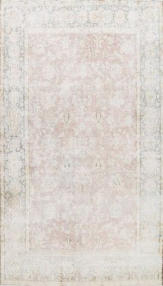 an antique rug with faded edges and floral design on the center, in pale tones