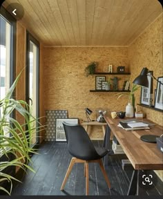 a home office with wood paneling and black chairs