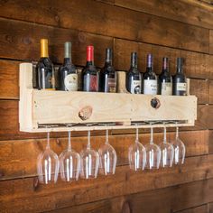 several wine glasses are hanging on a wooden rack