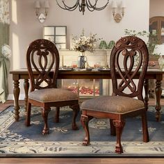 a dining room table with two chairs and a chandelier