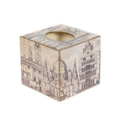 a tissue box with a drawing of buildings on it's sides and a candle holder in the middle