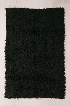 a black shaggy rug on a white background