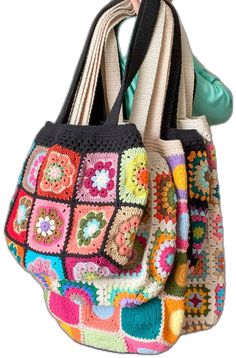 two crocheted purses are hanging on a hook with the handles down and one has a multicolored granny design