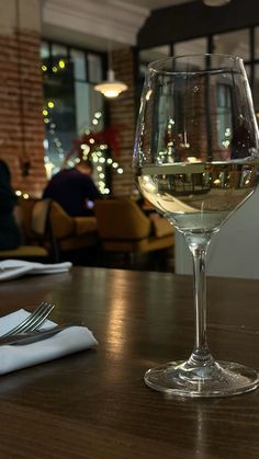 a glass of wine sitting on top of a wooden table