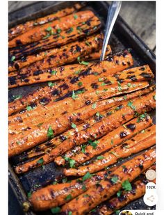 grilled carrots in a pan with a fork on the side and garnished with parsley